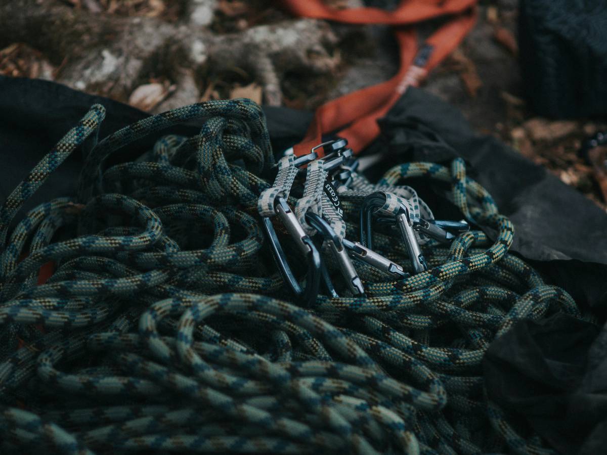 A smiling climber showcasing his toned physique next to his trusted body lock harness