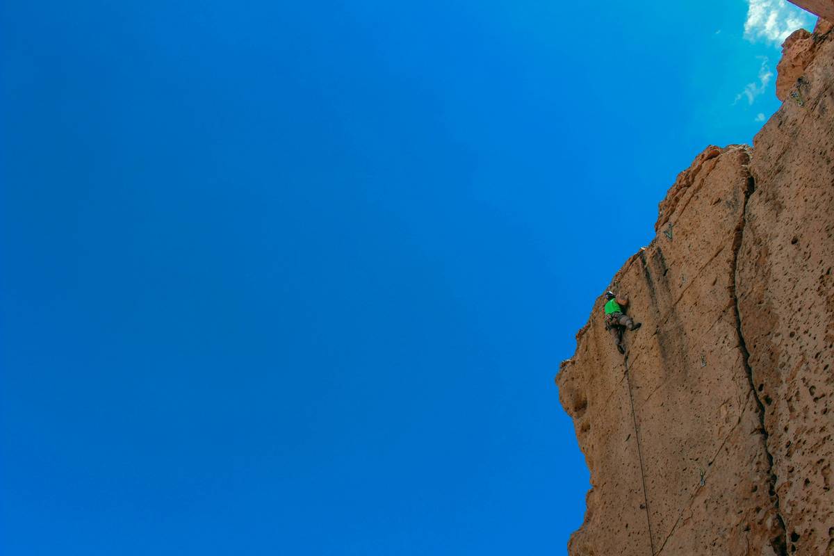 Photo of Sarah smiling mid-climb wearing her favorite rope ready harness