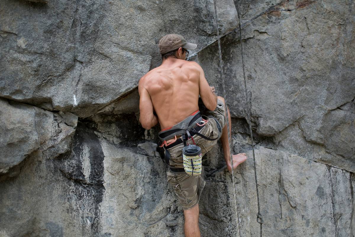 Woman celebrating after completing a challenging climb with her body lock harness