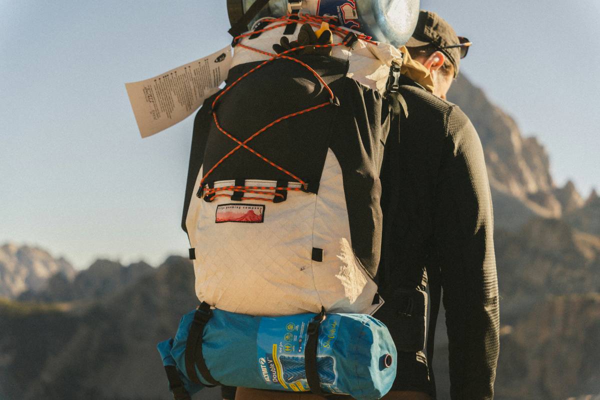 Illustration showing a climber checking their body lock harness for signs of wear.